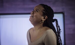 a woman with braids standing in front of a tv